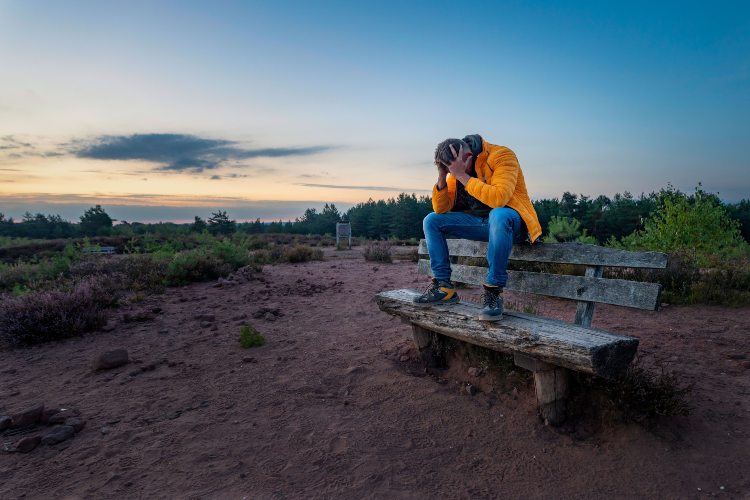 depressed man sitting on a bench